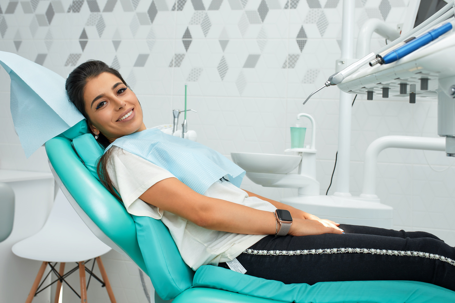 Overview of dental caries prevention.Woman at the dentist's chair during a dental procedure. Beautiful Woman smile close up. Healthy Smile. Beautiful Female Smile Piaskowanie zębów - na czym polega, czego nie robić po zabiegu, cena